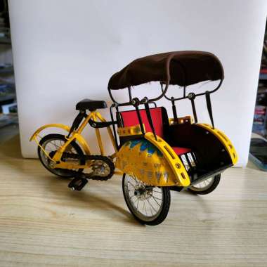 Miniatur becak warna kuning dari besi